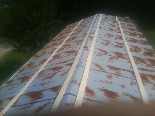 Rusted metal roof panels with new wood purlins before replacement — Storm Damage Roof Repair in Great Falls by Roofing Brothers