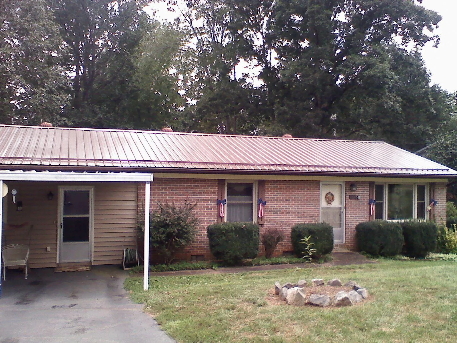 Bronze metal roof and carport on a brick ranch home — Roof Repair work by our crew in Great Falls